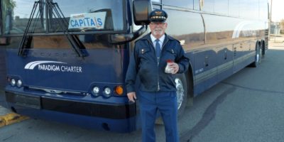 Professional driver at the wheel of a luxurious Paradigm Bus Charter in Saskatchewan, ensuring a safe and comfortable journey.